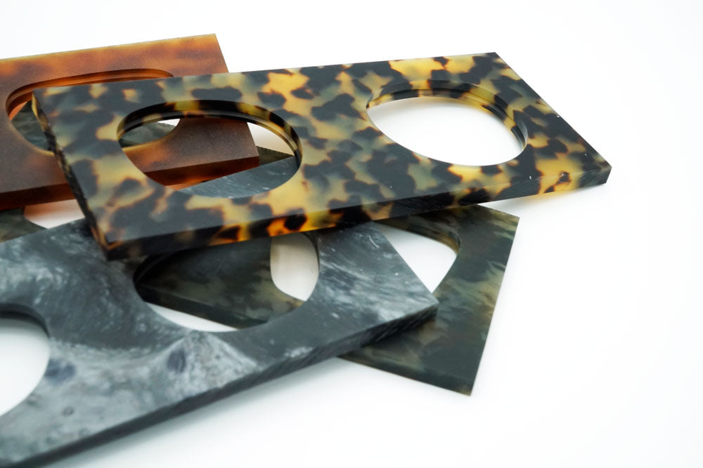 Sheets of acetate in different colors are laying on top of each other.